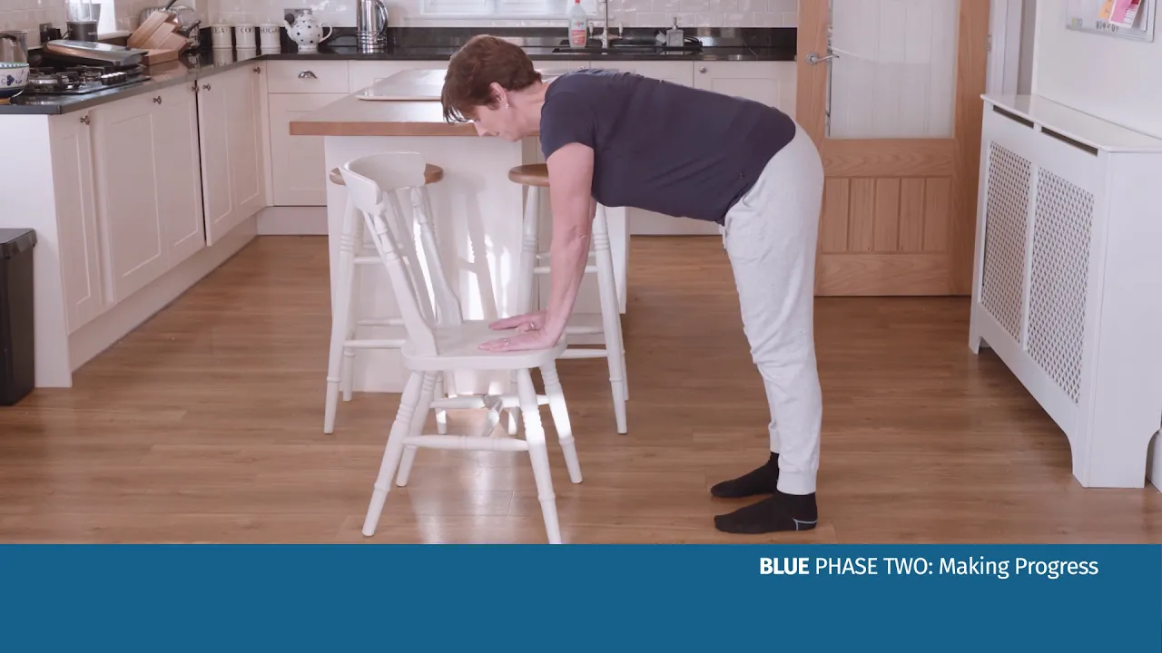 žena skláňajúca sa nad stoličkou