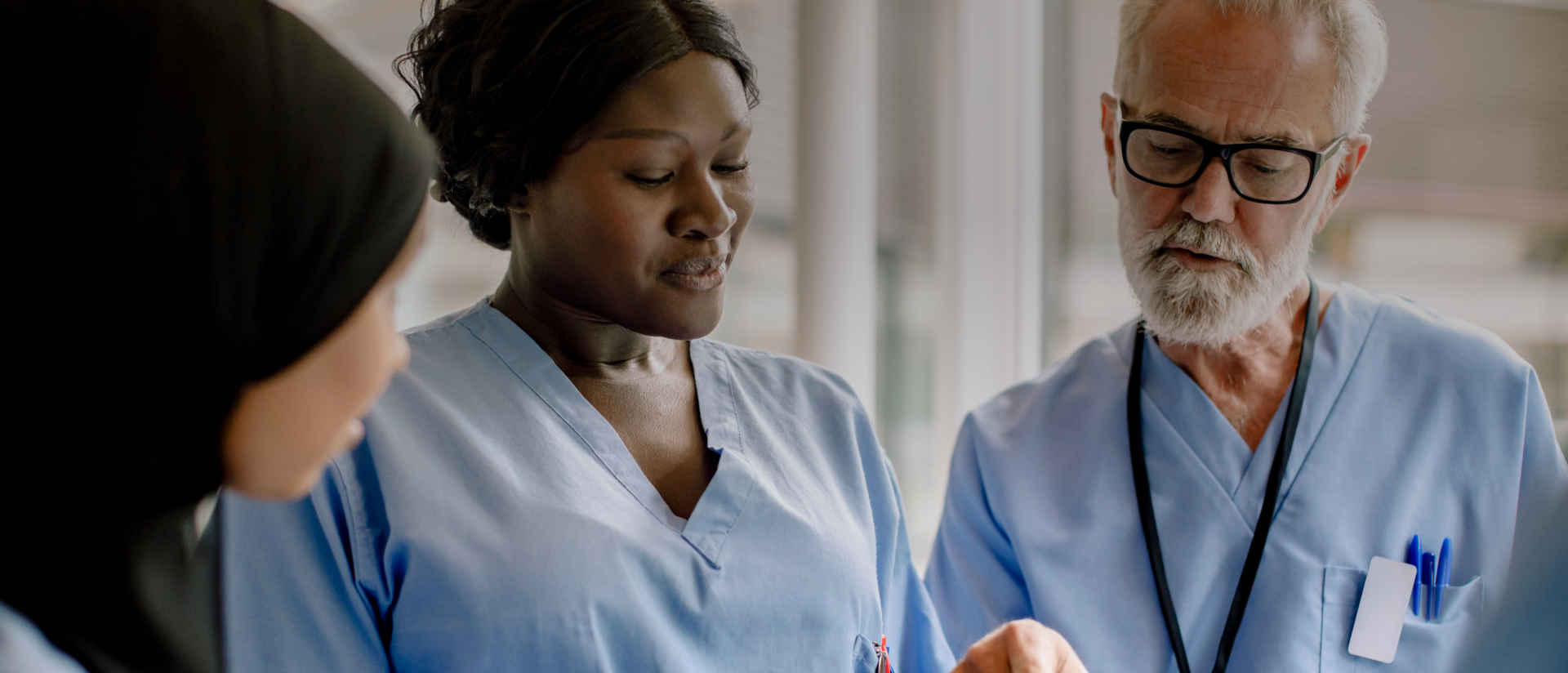 A man and two women looking at a tablet